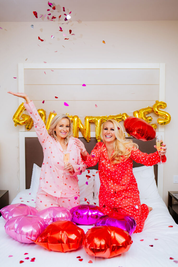 St. Pete Blogger, Jill DiGioia of The Lovely Flamingo celebrates Galentine's Day in heart pajamas throwing confetti and balloons at the Epicurean Hotel in Tampa Florida.
