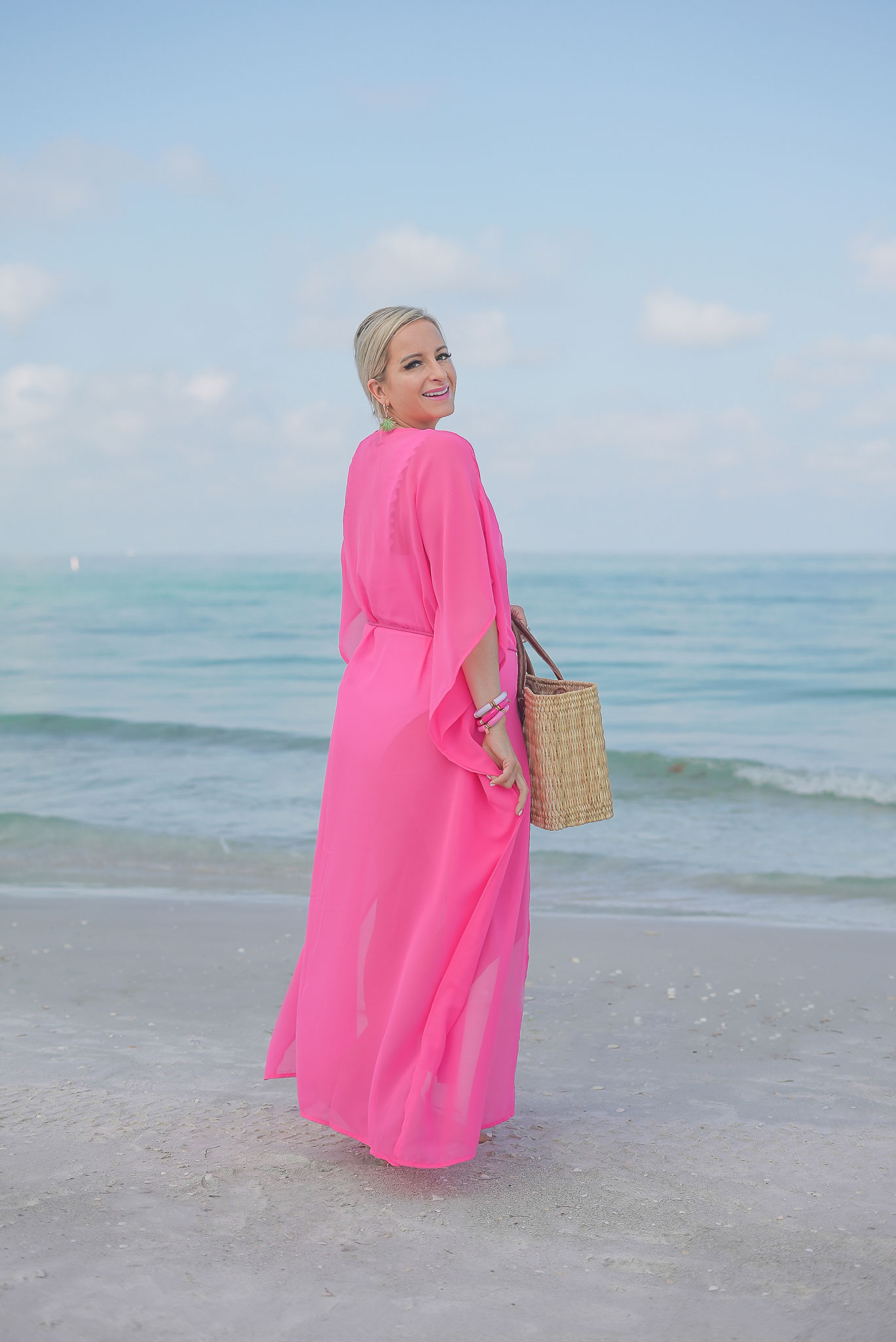 Florida Blogger, Jill DiGioia, The Lovely Flamingo wears Palmetto Palm Leaf earrings from her new beach earring collection with a hot pink beach coverup maxi kimono over a white ruffle one piece and walking on St. Pete Beach.