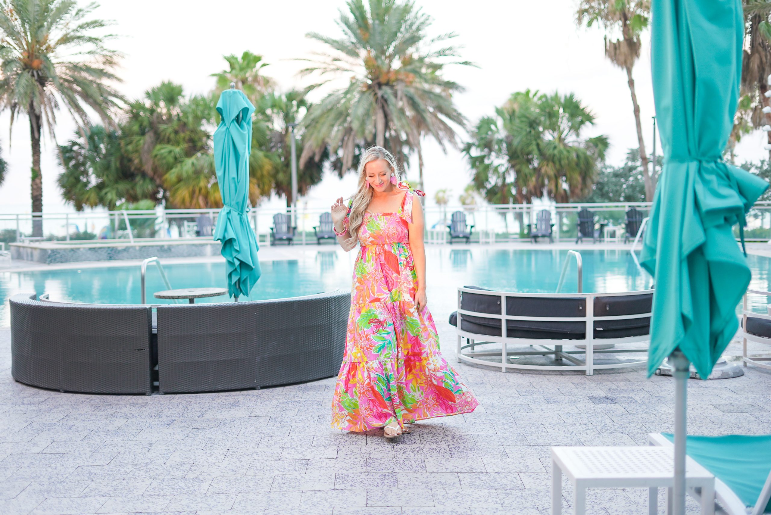 Florida Blogger, The lovely Flamingo, Jill DiGioia wears a colorful maxi dress in front of the pool at the Wyndham Grand Clearwater Beach.