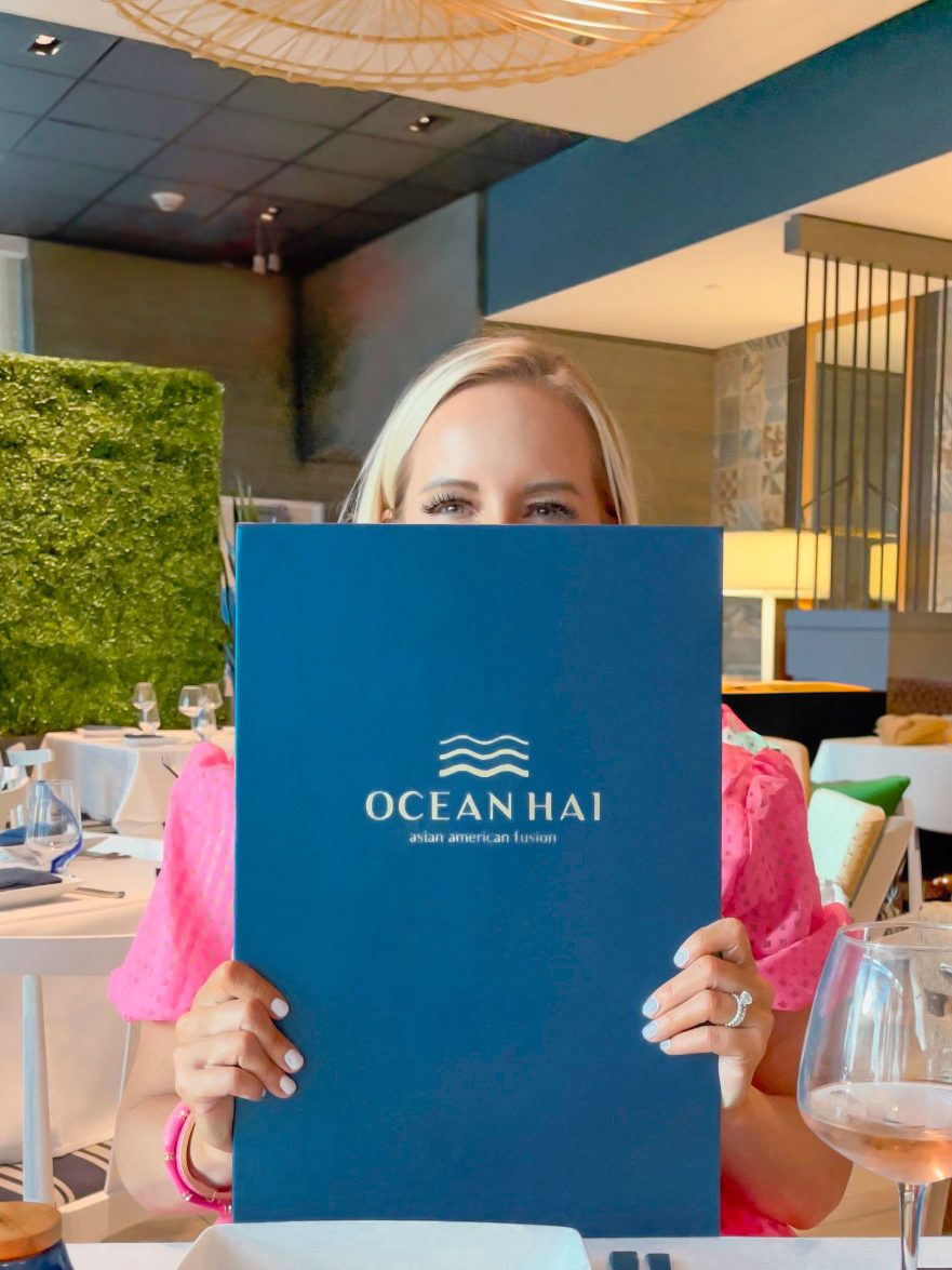 Florida Blogger, The Lovely Flamingo, Jill DiGioia opens the Ocean Hai menu at Wyndham Grand Clearwater Beach.