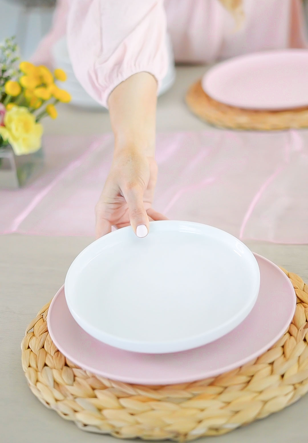 Florida lifestyle and home blogger Jill DiGioia shares an easy spring tablescape layering woven placemats, pink plates, and white plates.